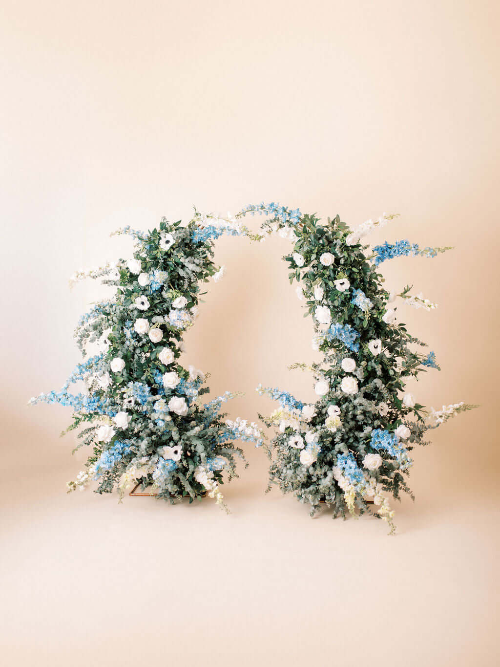 The Aurora Full Collection arch featuring white and dusty blue floral arrangements.